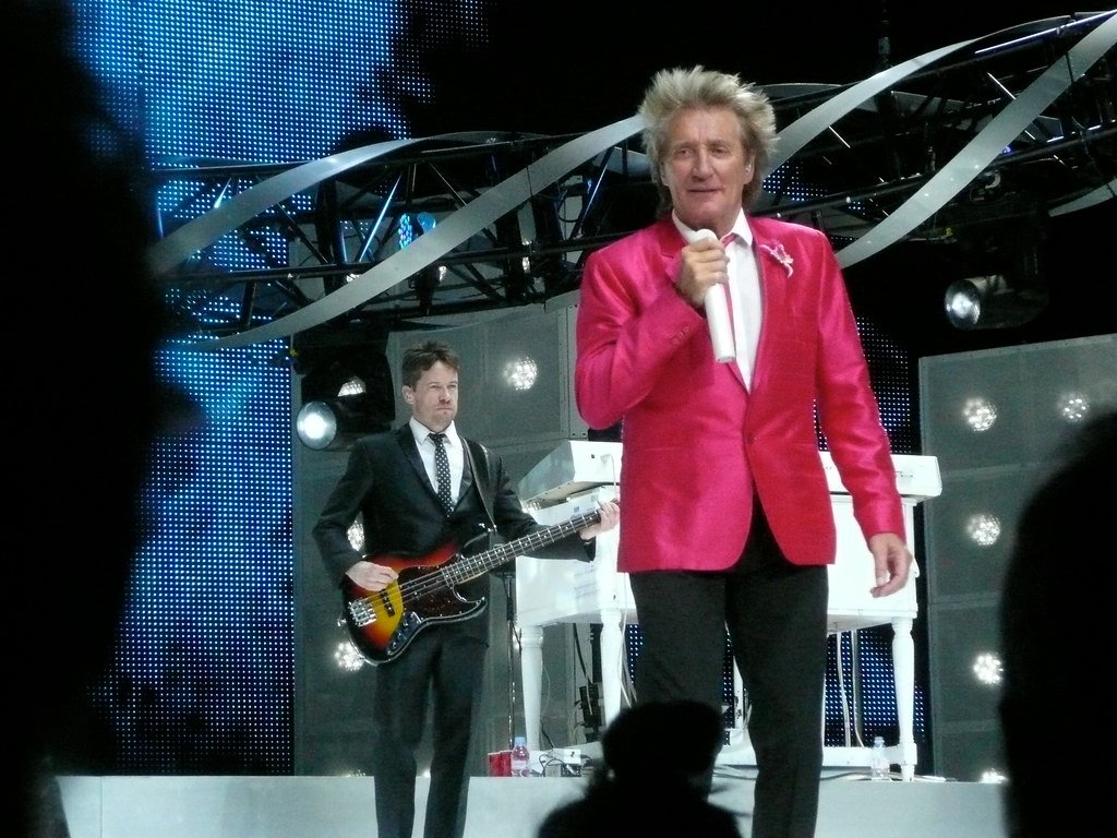 Rod Stewart performing live on stage with guitar